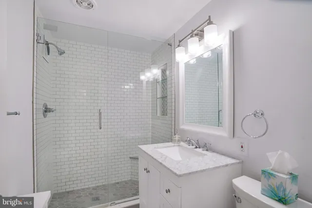 a bathroom with a sink mirror and a shower