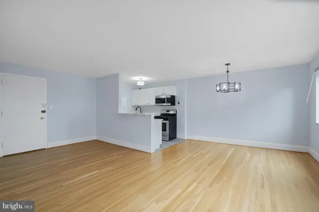 a view of a kitchen with wooden floor and a ceiling fan