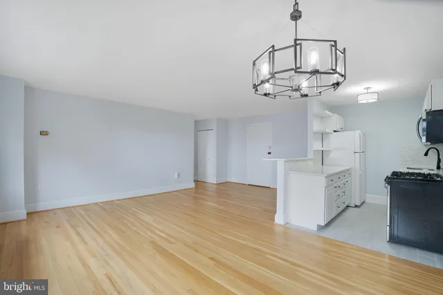 a view of a kitchen with flat screen tv and wooden floor