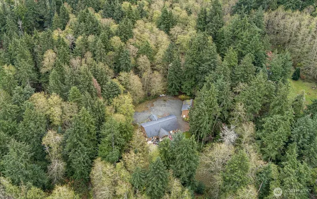 an aerial view of residential house with outdoor space and trees all around