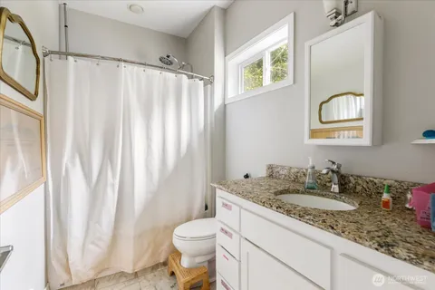 a bathroom with a granite countertop sink and a mirror