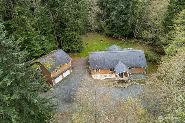 an aerial view of a house with yard and tree s