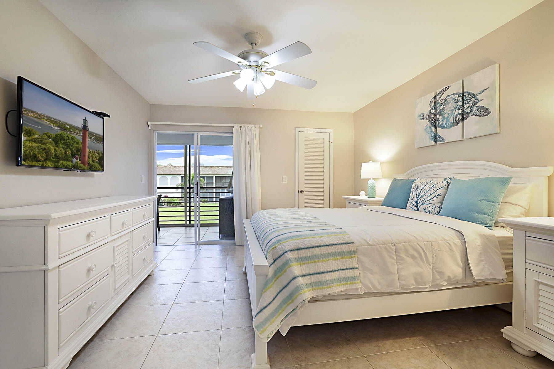 755 Saturn Street, Unit F203 Jupiter, FL 33477 - Photo 27 of 36 a bedroom with a bed and a chandelier