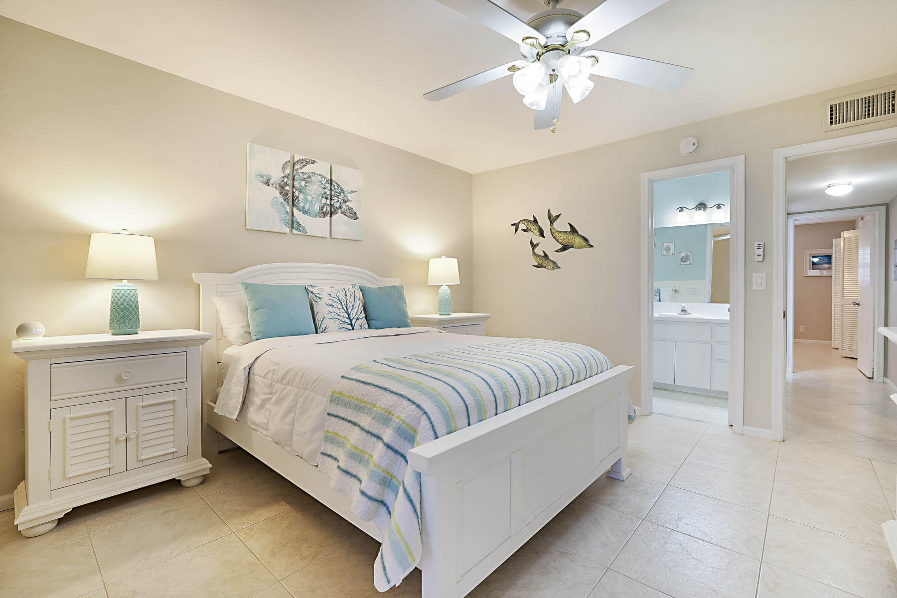755 Saturn Street, Unit F203 Jupiter, FL 33477 - Photo 28 of 36 a spacious bedroom with a bed and a chandelier