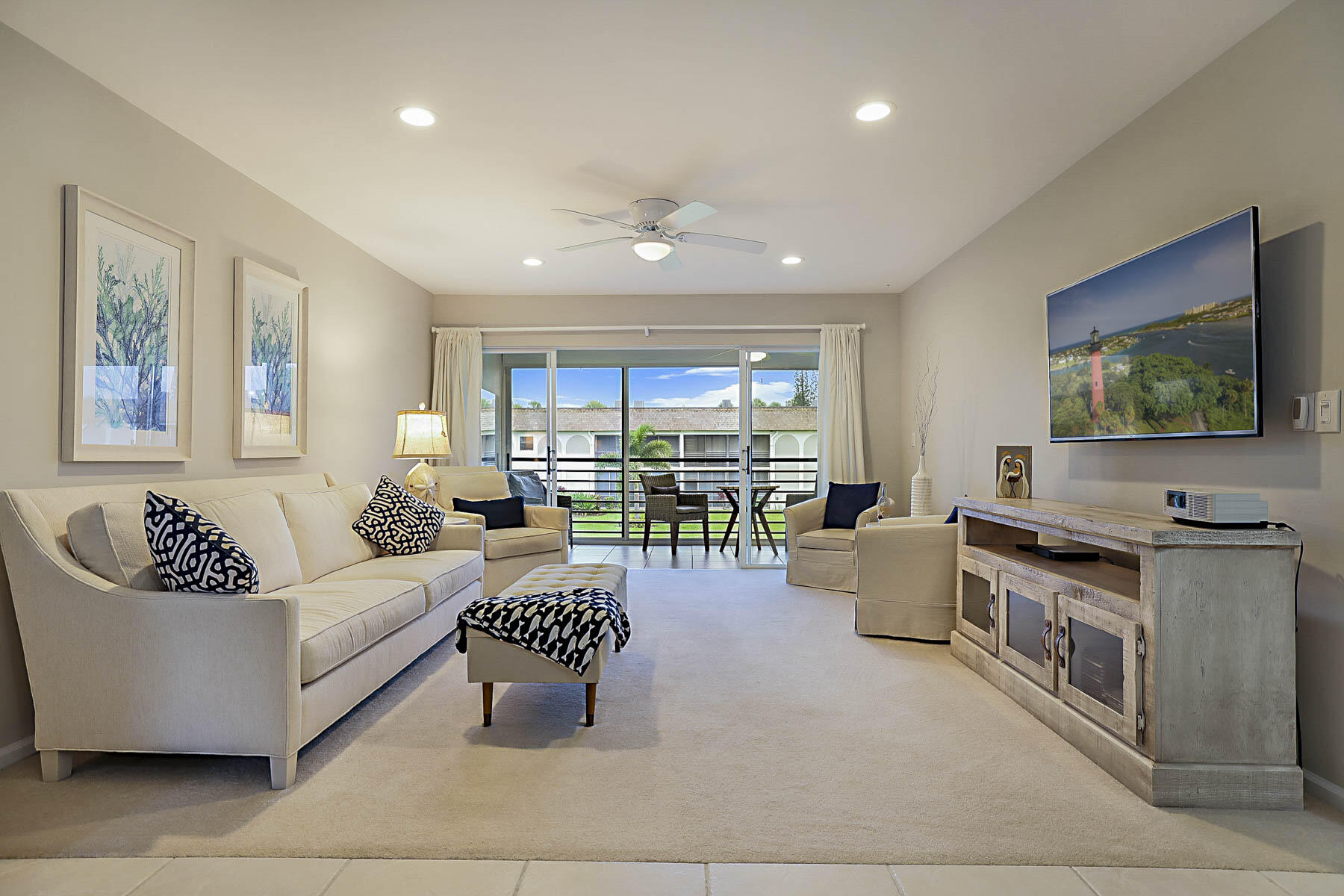 755 Saturn Street, Unit F203 Jupiter, FL 33477 - Photo 6 of 36 a living room with furniture and a flat screen tv