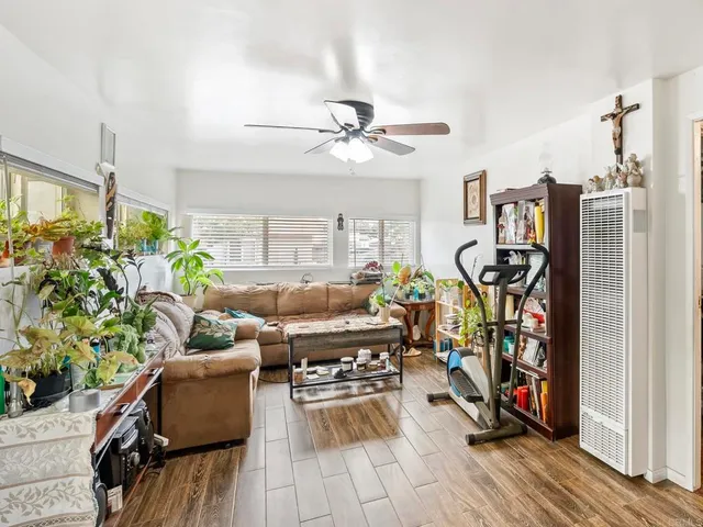 a living room with patio furniture and a wooden floor