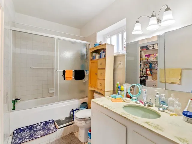a bathroom with a granite countertop sink mirror vanity and toilet