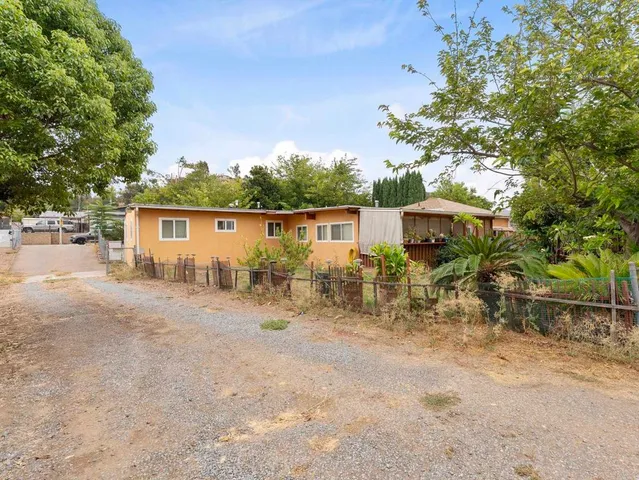 a view of a house with backyard and sitting area