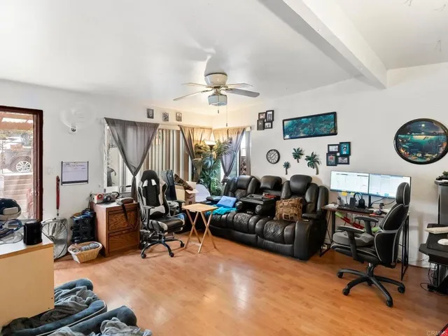 a living room with furniture a clock on the desk and a flat screen tv