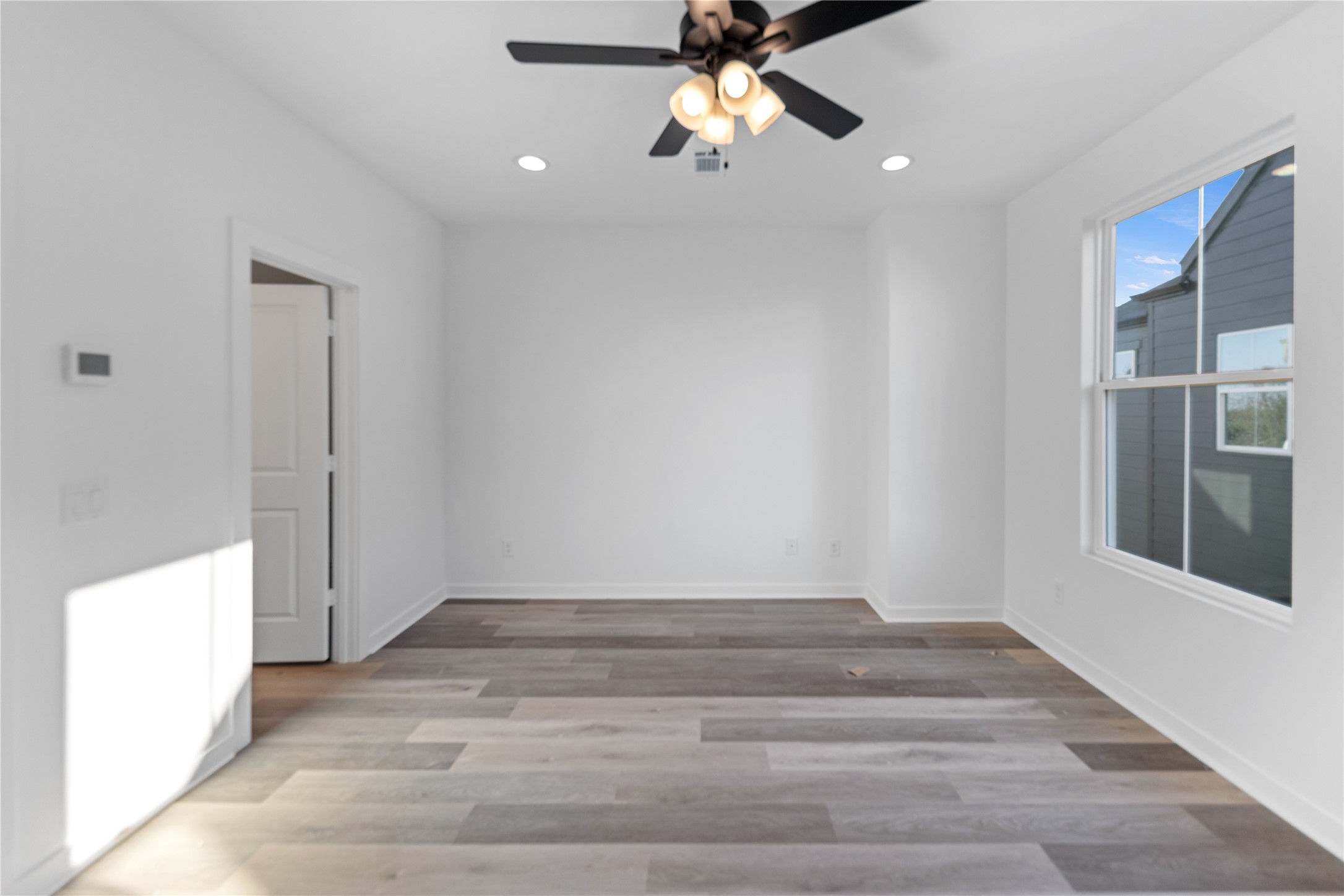 2702 Winbern Street, Unit A Houston, TX 77004 - Photo 3 of 16 a view of empty room with wooden floor and fan