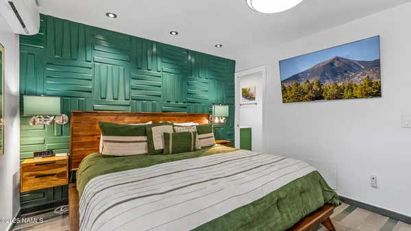 a bedroom with furniture and a flat screen tv