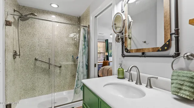 a bathroom with a granite countertop sink and a mirror
