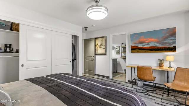 a view of a bedroom with a bed and wooden floor