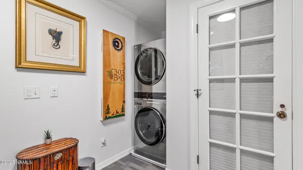 a living room with painting on the wall and a potted plant
