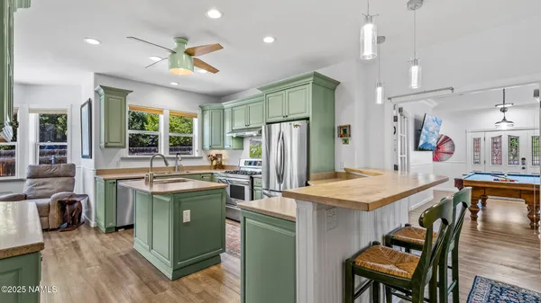 a kitchen with kitchen island stainless steel appliances a stove sink and refrigerator