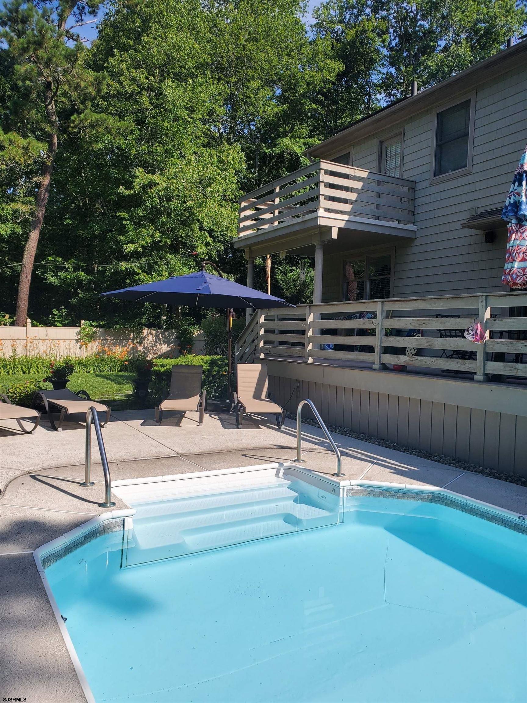 25 Brookside Drive Egg Harbor Township, NJ 08234 - Photo 37 of 47 a patio with a table and chairs under an umbrella