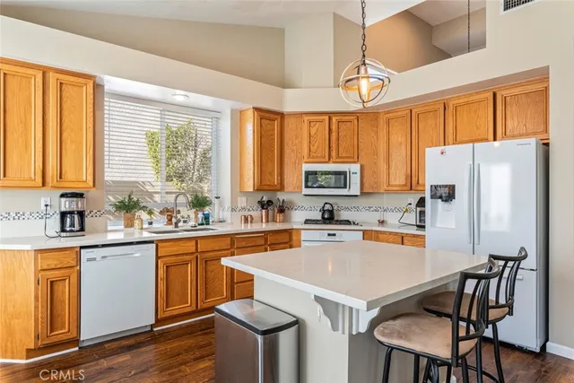 a kitchen with a refrigerator a stove a sink dishwasher and white cabinets with wooden floor
