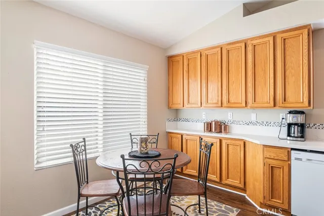 a kitchen with a table chairs and white cabinets