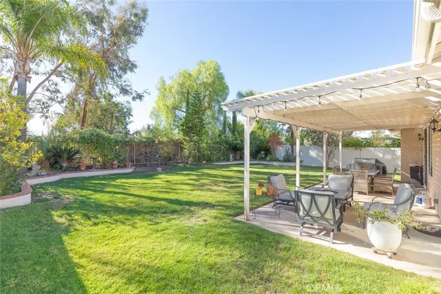 a view of a patio with a table chairs and a big yard