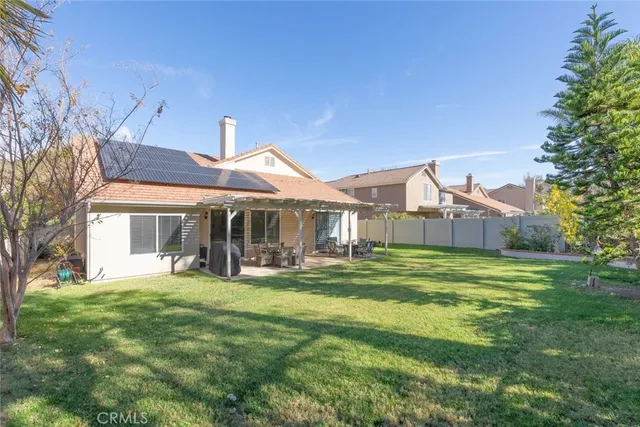 a front view of a house with a garden and trees