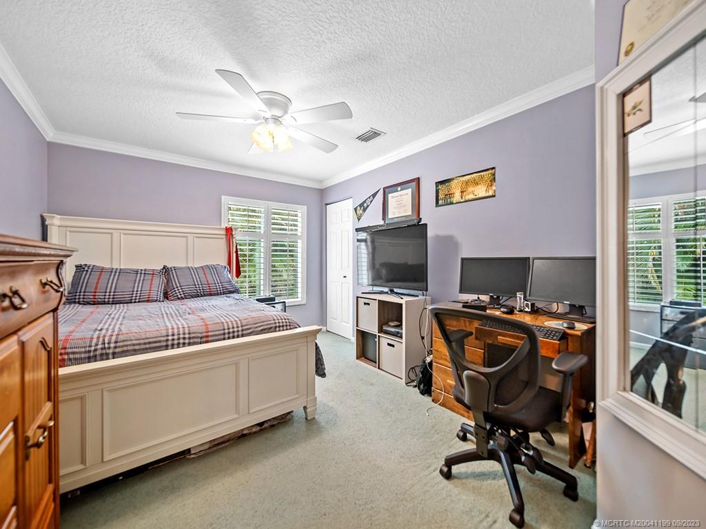 2498 Southeast Springtree Place Stuart, FL 34997 - Photo 14 of 25 a bedroom with furniture and a flat screen tv