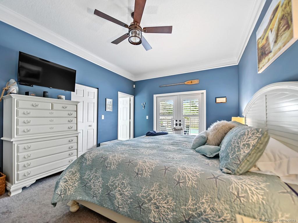 2498 Southeast Springtree Place Stuart, FL 34997 - Photo 15 of 25 a bedroom with a large bed and flat tv screen