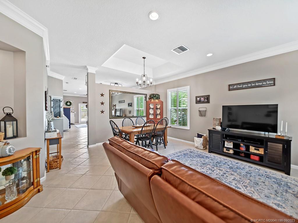 2498 Southeast Springtree Place Stuart, FL 34997 - Photo 3 of 25 a living room with furniture and a flat screen tv