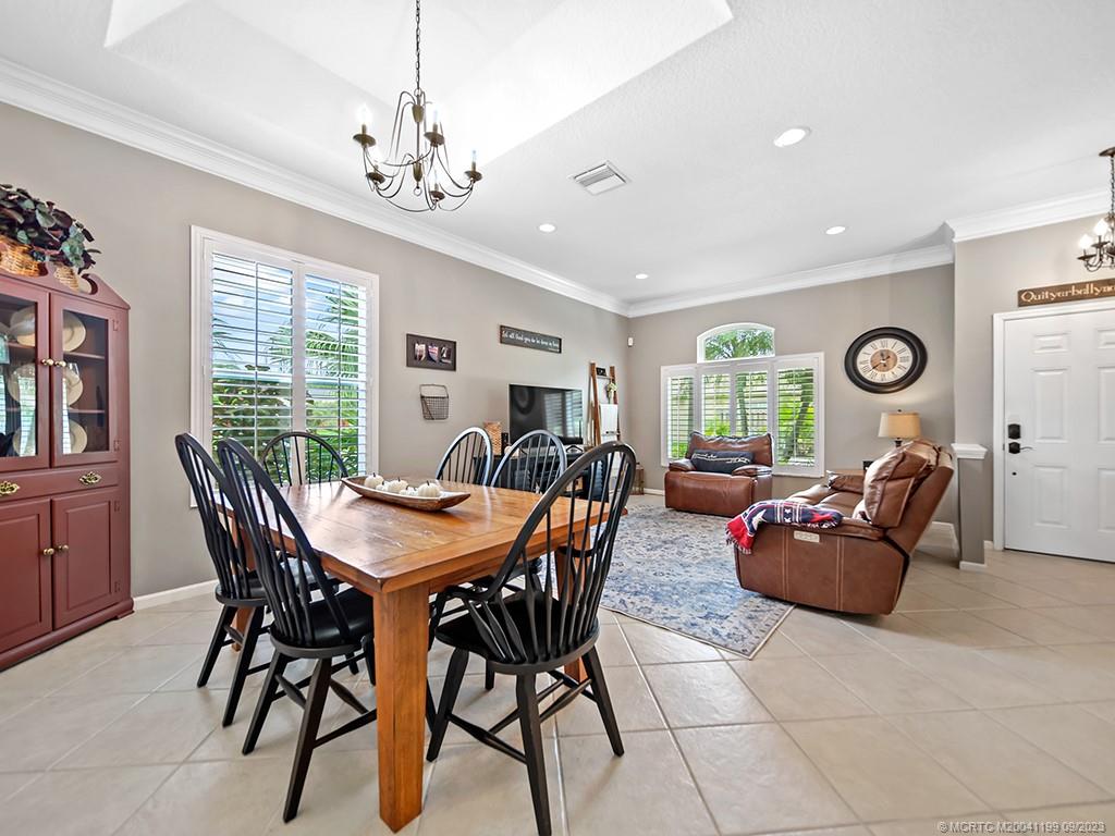2498 Southeast Springtree Place Stuart, FL 34997 - Photo 4 of 25 a living room with furniture a chandelier and a window