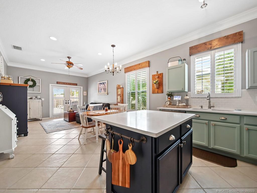 2498 Southeast Springtree Place Stuart, FL 34997 - Photo 6 of 25 a kitchen with a sink a counter top space and stainless steel appliances