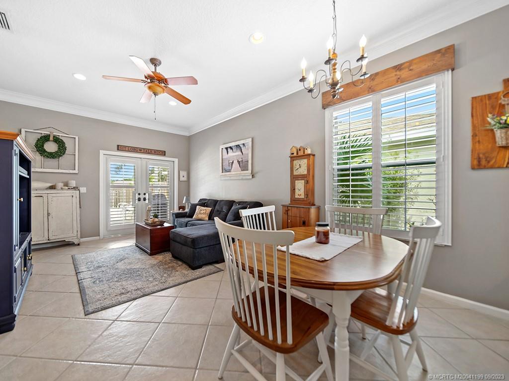 2498 Southeast Springtree Place Stuart, FL 34997 - Photo 8 of 25 a dining room with furniture a chandelier and window