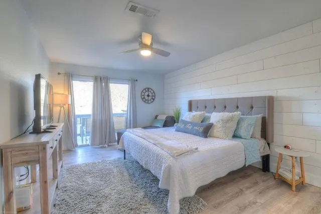 a bedroom with a large bed and a flat screen tv