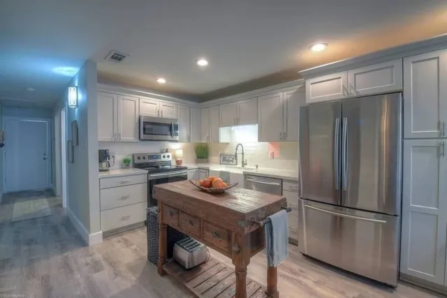 a kitchen with a refrigerator and a stove top oven