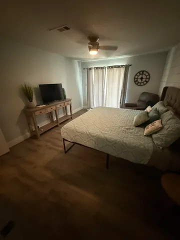 a bedroom with a bed and wooden floor