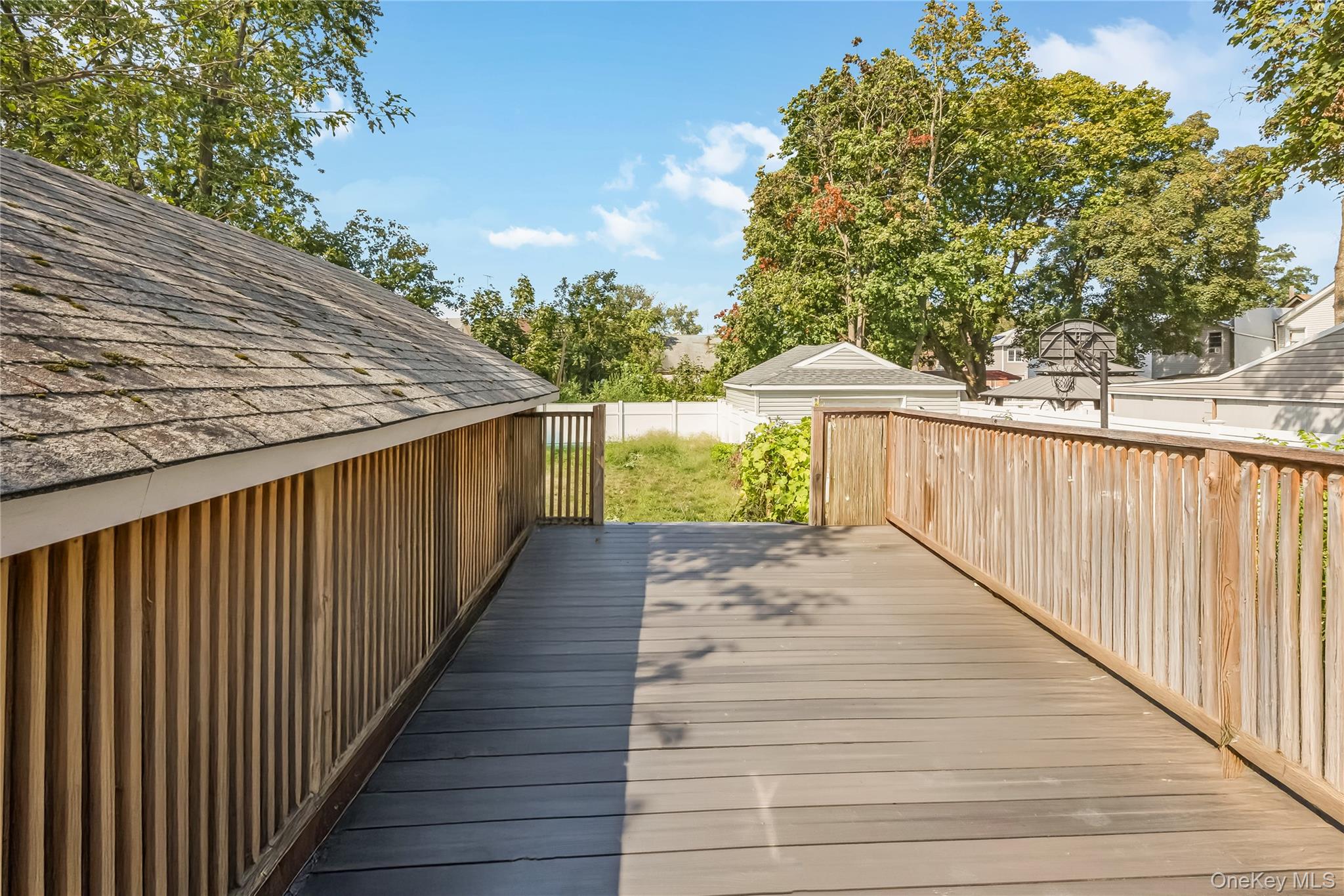 102-18 216th Street Queens, NY 11429 - Photo 18 of 23 a balcony with wooden floor and trees in the back