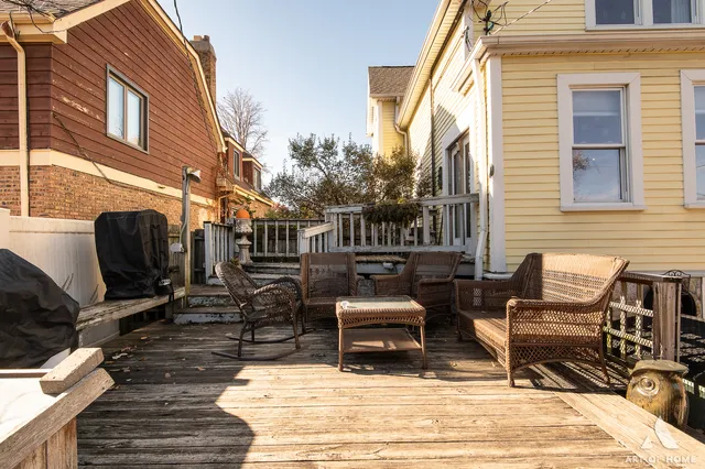 a view of a patio with table and chairs with wooden floor and fence