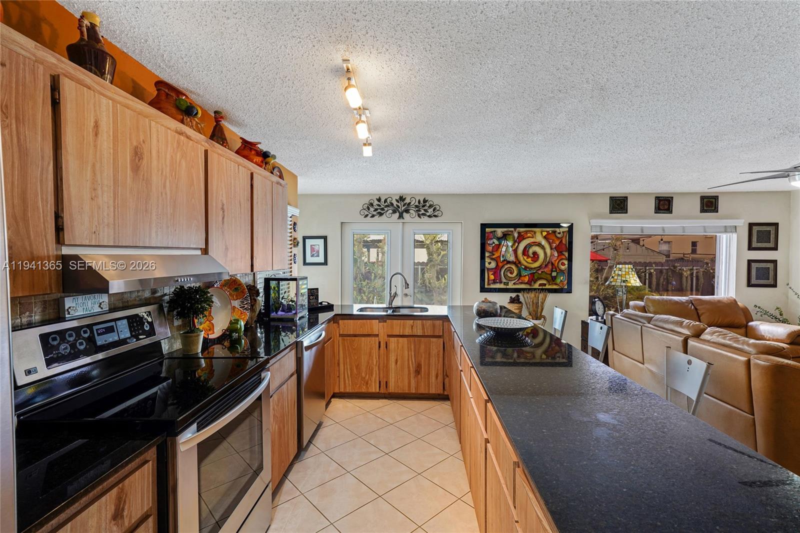 7256 Southwest 16th Street Miami, FL 33155 - Photo 8 of 25 a kitchen with stainless steel appliances a stove a sink and a refrigerator