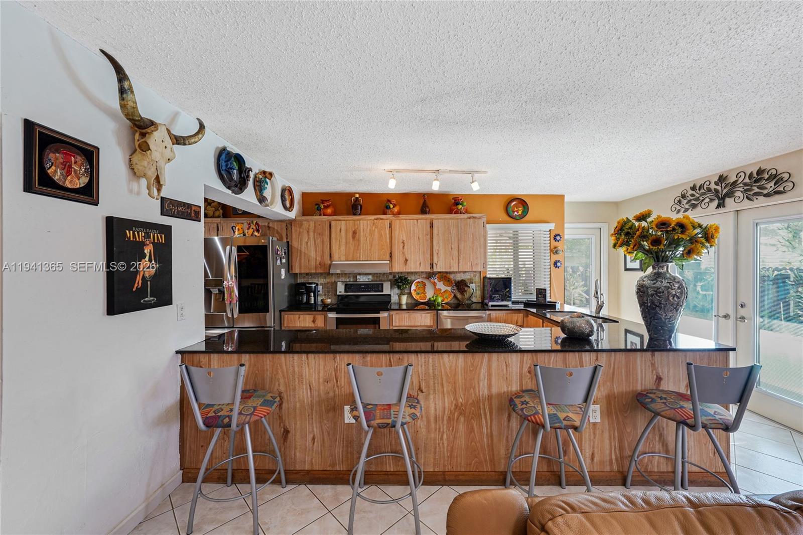 7256 Southwest 16th Street Miami, FL 33155 - Photo 9 of 25 a kitchen with stainless steel appliances kitchen island granite countertop a table and chairs