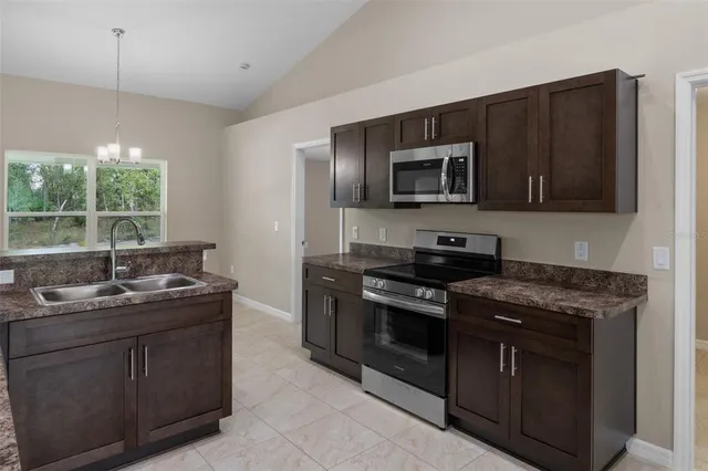 a kitchen with stainless steel appliances granite countertop a stove a sink and a microwave