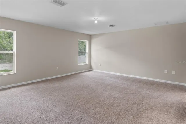 a view of an empty room with closet and a window