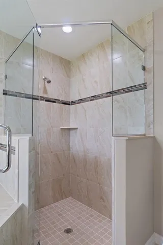 a bathroom with a granite countertop double vanity sink a mirror and a shower