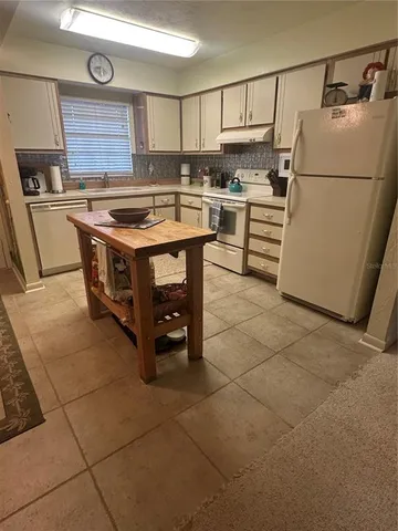 a kitchen with a stove a refrigerator and a cabinets