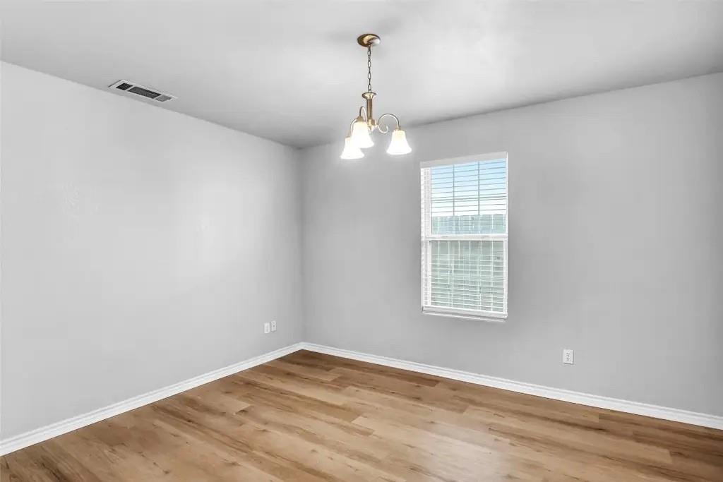 1915 Shaw Street Dallas, TX 75212 - Photo 11 of 34 an empty room with wooden floor exposed radiator and windows