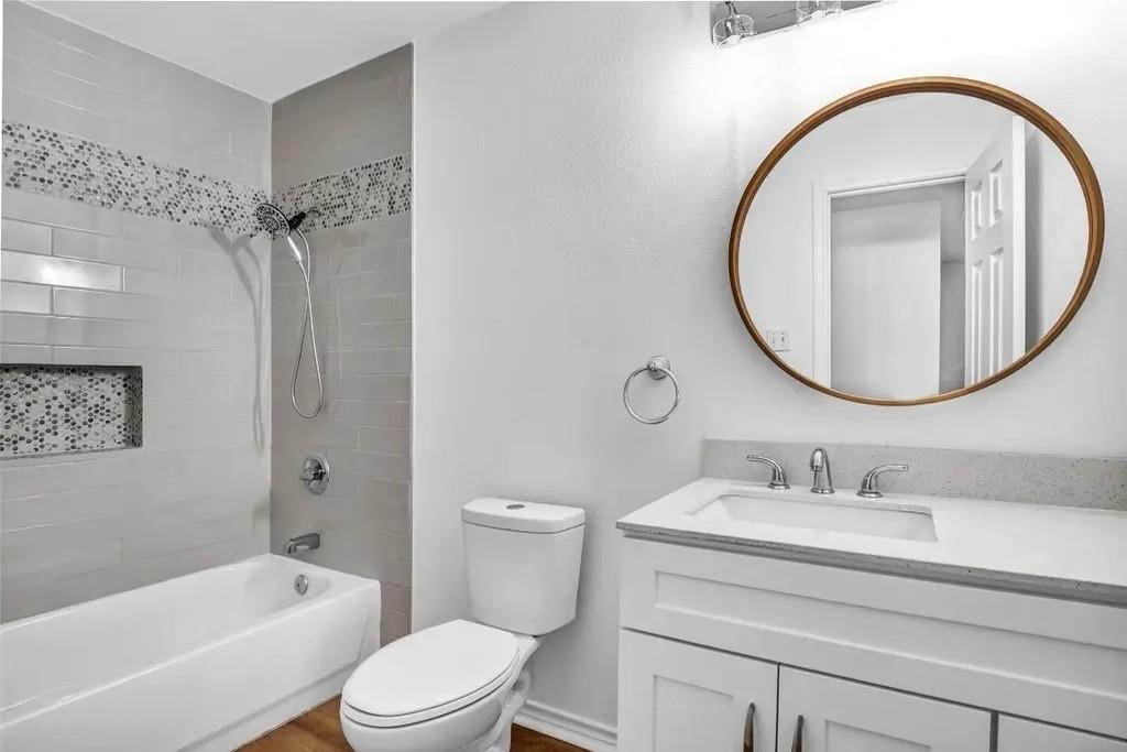 1915 Shaw Street Dallas, TX 75212 - Photo 12 of 34 a bathroom with a sink a mirror a toilet and a bathtub