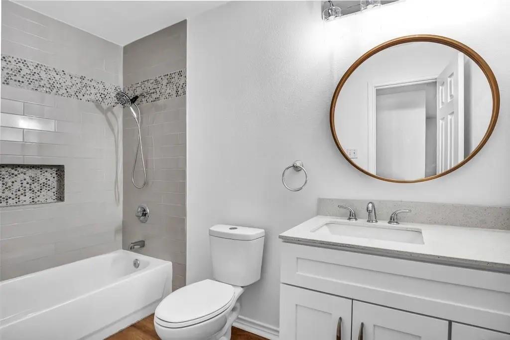 1915 Shaw Street Dallas, TX 75212 - Photo 24 of 34 a bathroom with a sink a mirror a toilet and a bathtub