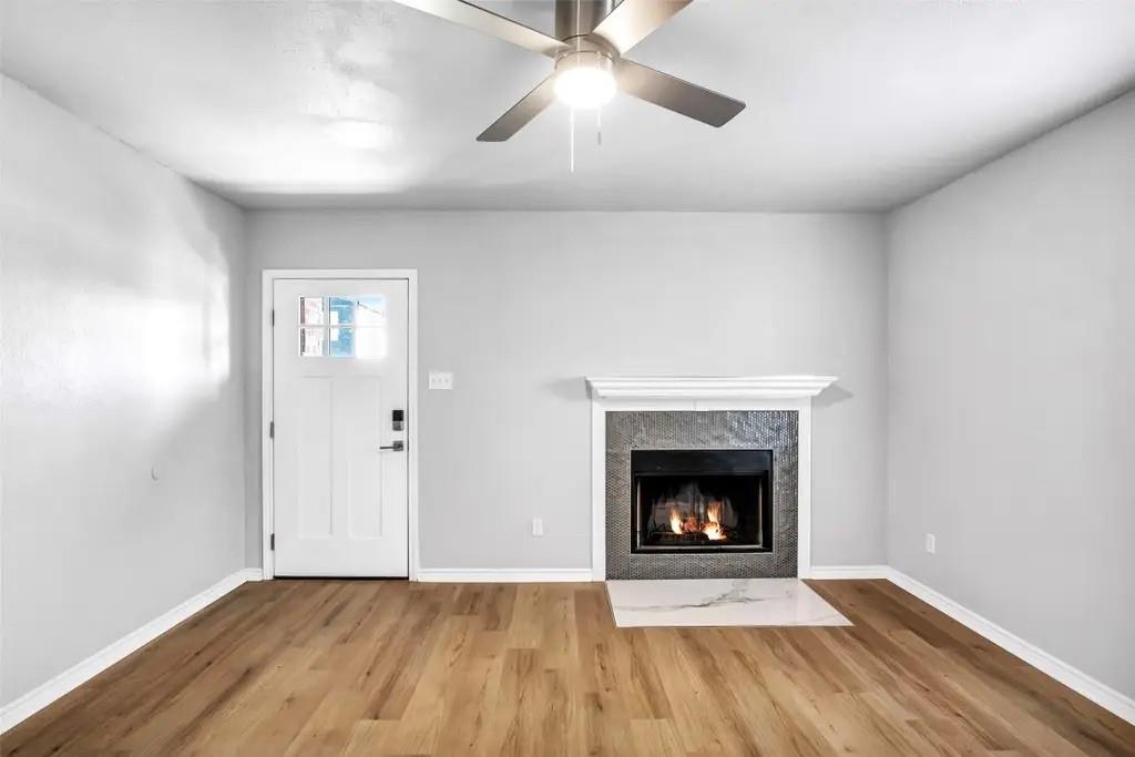 1915 Shaw Street Dallas, TX 75212 - Photo 3 of 34 a view of an empty room with wooden floor fireplace and a window