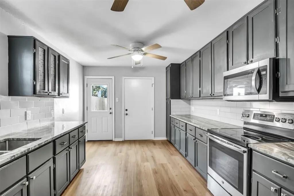 1915 Shaw Street Dallas, TX 75212 - Photo 6 of 34 a kitchen with stainless steel appliances granite countertop a sink stove and cabinets