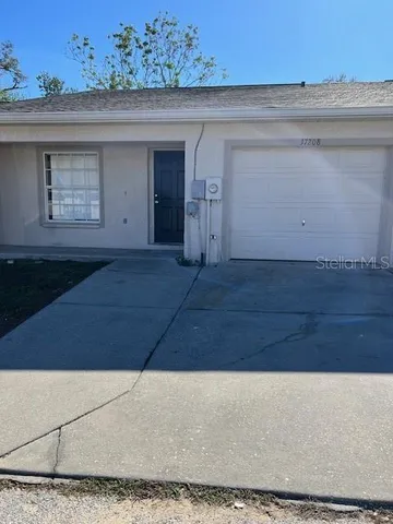 a view of hallway with a window and a refrigerator