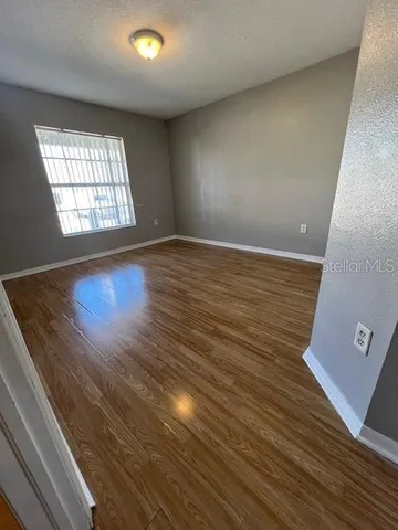 a view of an empty room with wooden floor