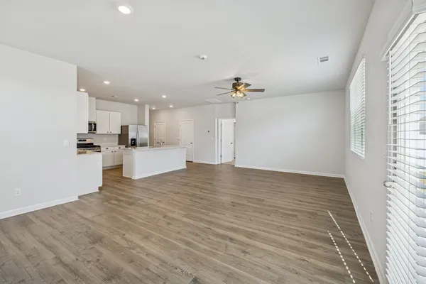 a view of an empty room with kitchen appliances and a window