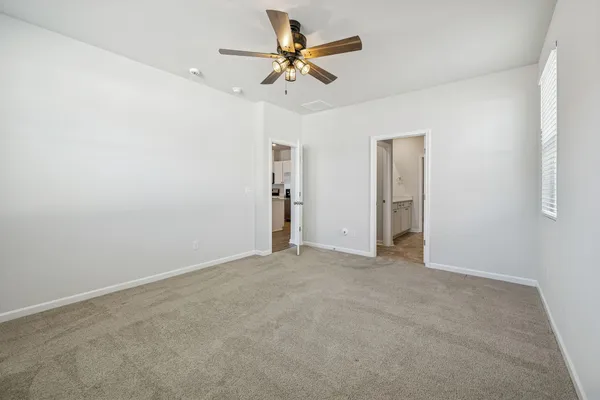 an empty room with closet and a ceiling fan
